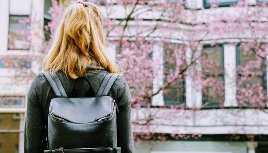 Woman wearing backpack facing concrete building.jpg