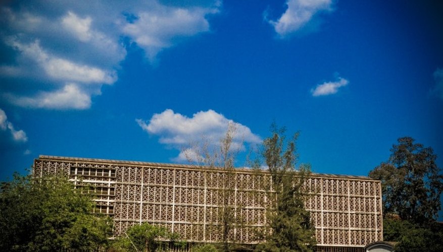 White concrete building near green trees under blue sky during daytime.jpg