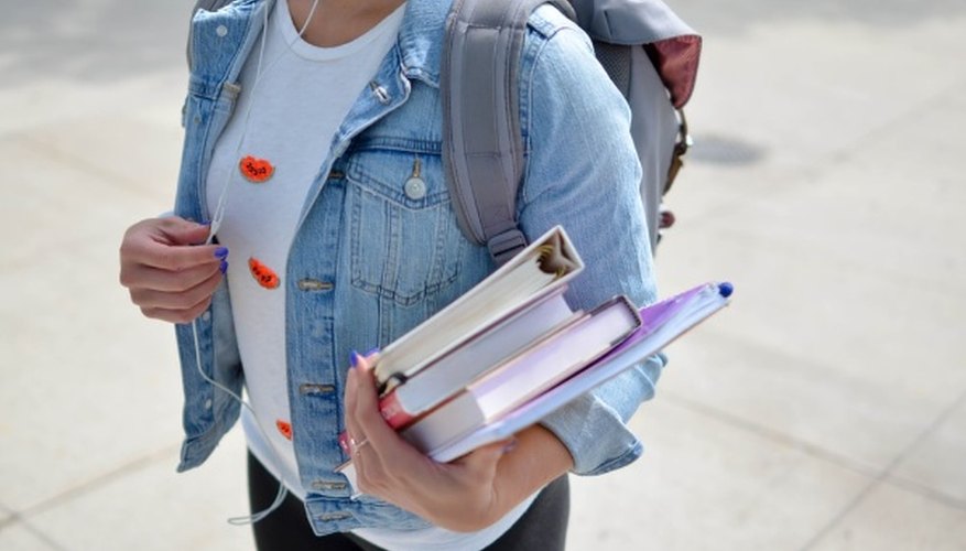 Woman wearing blue denim jacket holding book.jpg