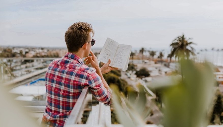 Man reading book on balcony during daytim.jpg