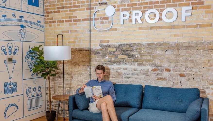 Man sitting on blue sofa while reading book.jpg