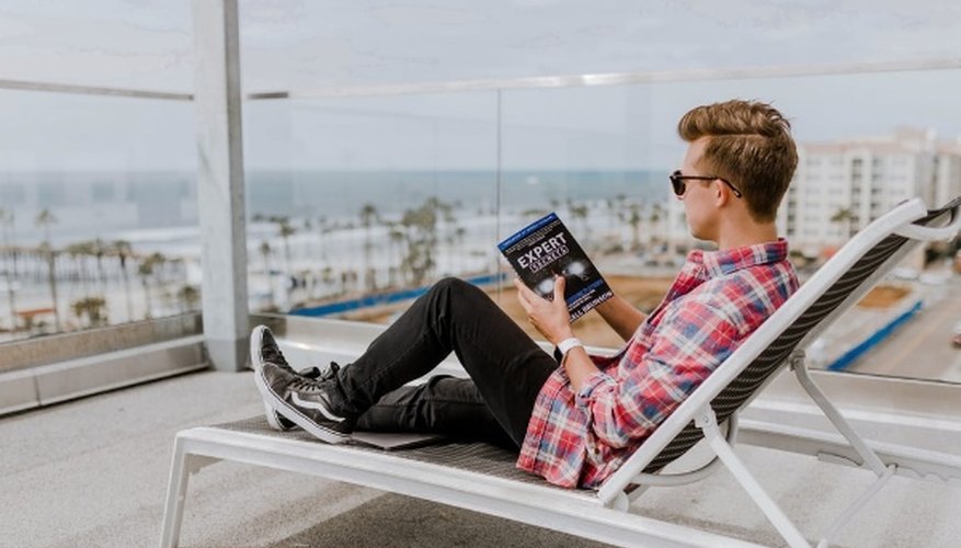 Man sitting lounge chair reading a book.jpg