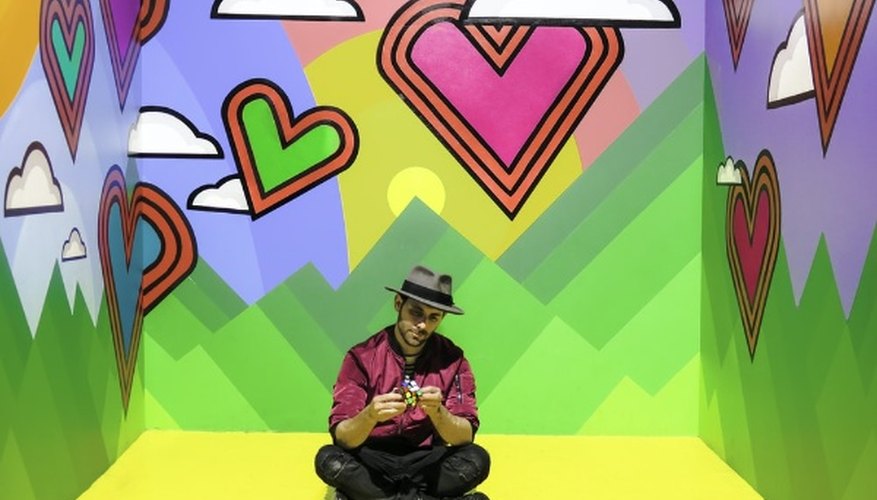 Man sitting on multicolored 3d wallpaper room.jpg