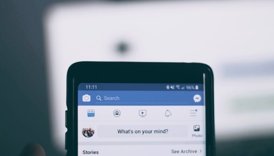 Person holding smartphone using facebook account.jpg
