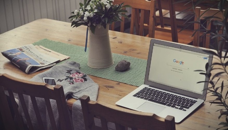 Laptop on top of table beside vase of flowers.jpg