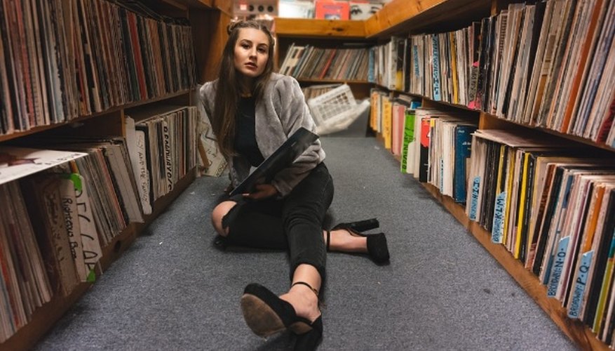 Woman sitting on floor between bookshelves.jpg