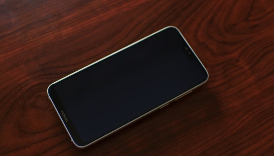Black smartphone on red stained wood panel.jpg
