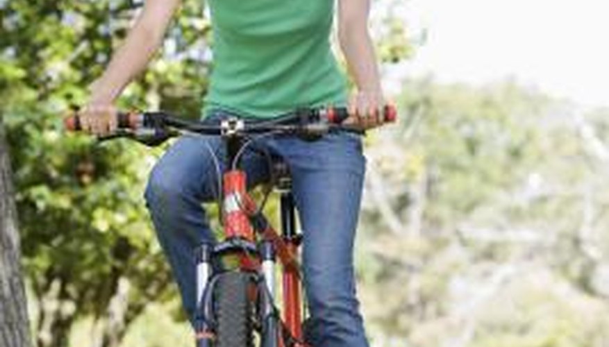 Photo Credit: BananaStock/BananaStock/Getty Images Woman riding bike