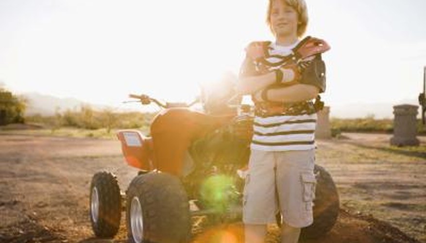 Photo Credit: Jupiterimages/Brand X Pictures/Getty Images Boy next to ATV
