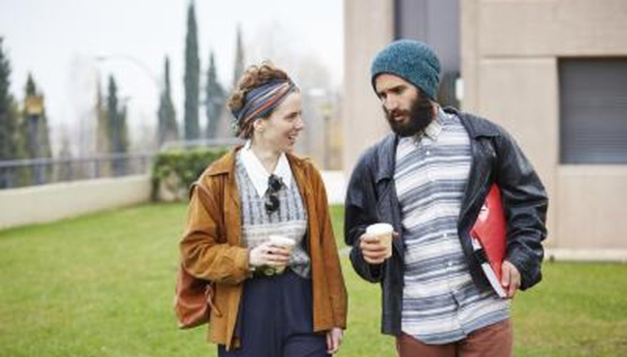 Hip, fashion students walking through campus with coffee and binders