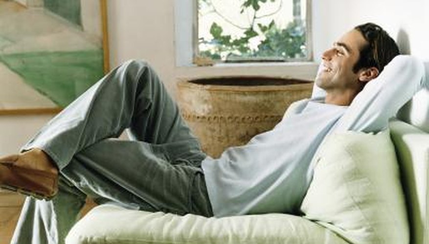 Young man relaxing in armchair, smiling.