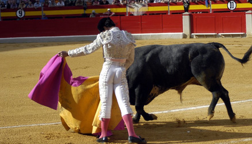 Bullfighter, wearing traditional pink socks and using a yellow-and-pink cape.