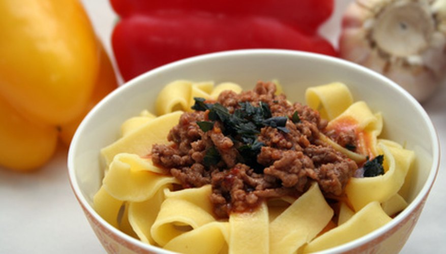Pasta topped with fresh vegetables and ground beef: a healthy, satisfying meal.