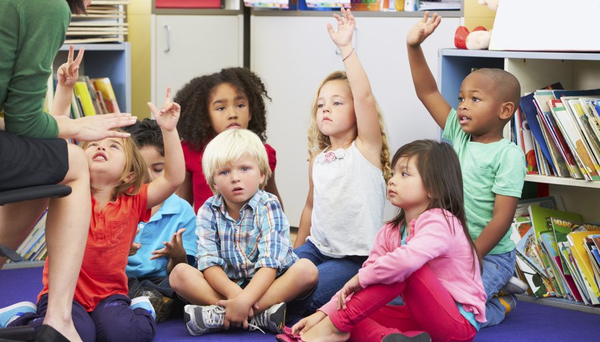 Teacher talking to kindergarteners in classroom.