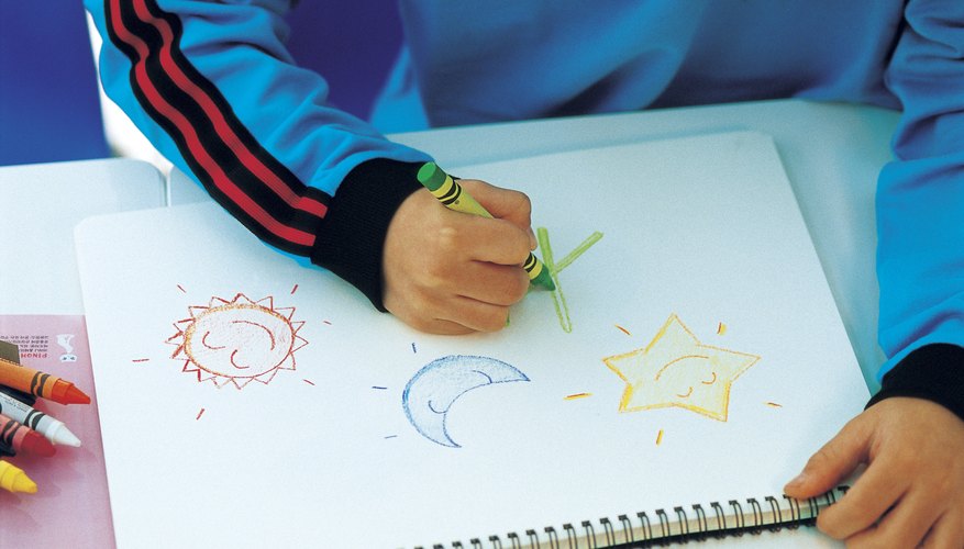 Young student coloring in notepad