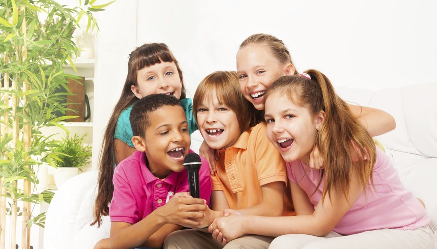 Group of young students holding up microphone