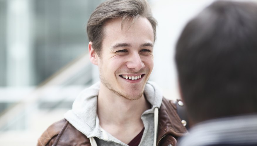 Man smiling while having conversation with friend