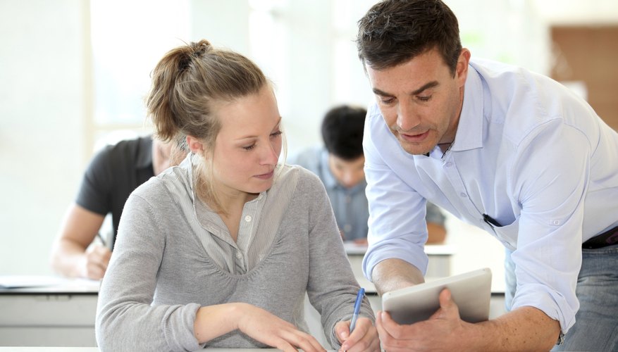 College student looking at professor's tablet in classroom