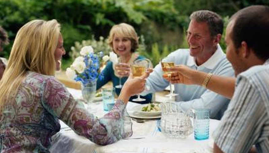 Un grupo de personas hacen un brindis en una mesa exterior.