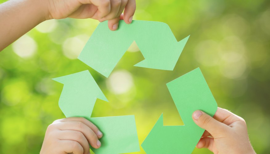 Three small hands holding recycling arrows