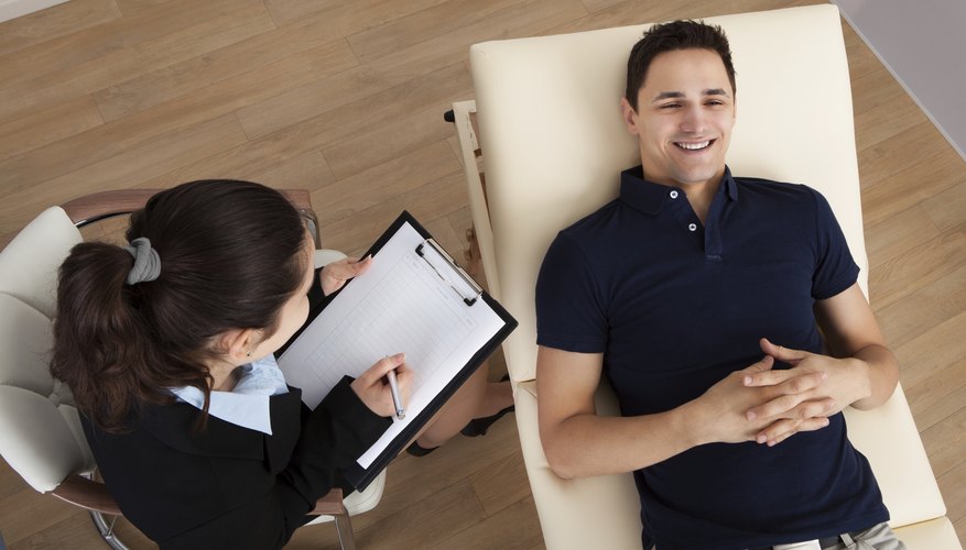 A high-angle view of a patient communicating with his therapist.