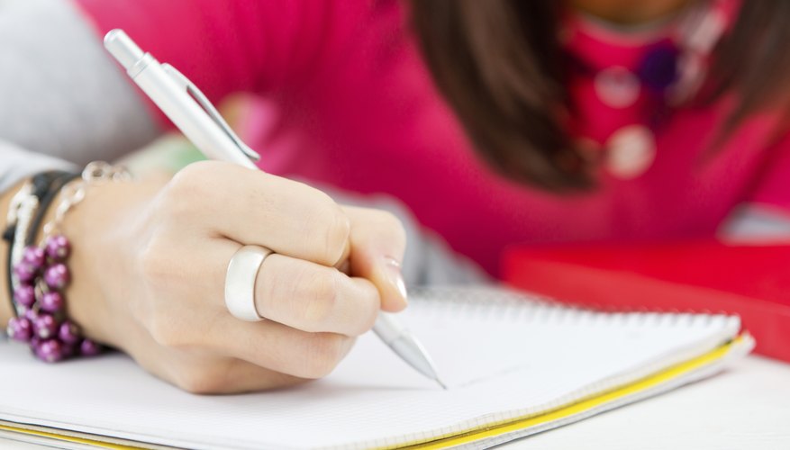 Close-up of girl writing in notebook.