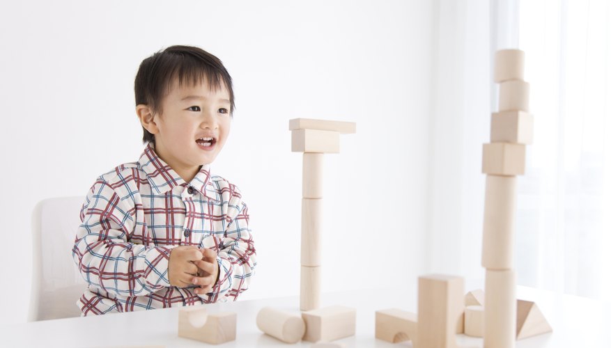 Smiling young preschool boy with building blocks.