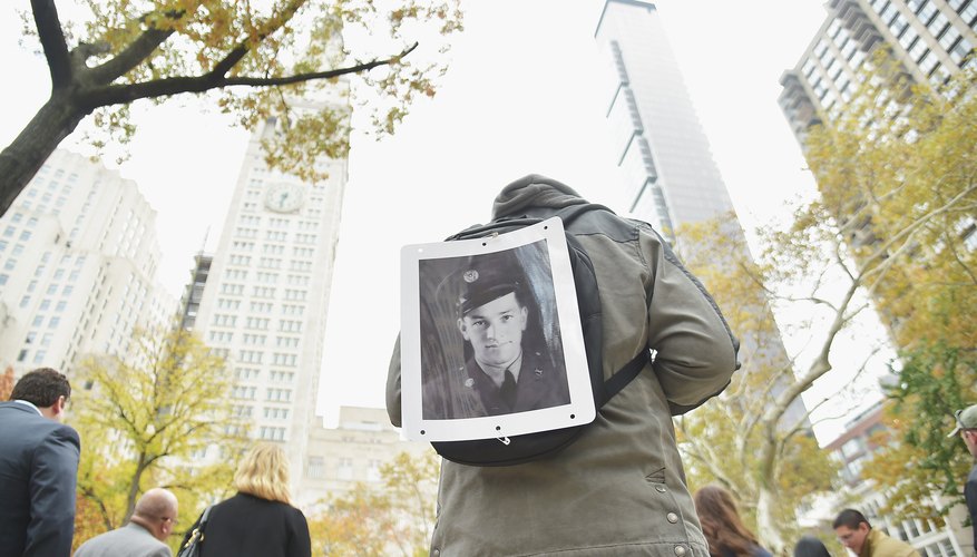 A parade attendee on Veteran's Day exhibiting a portrait of his grandfather who served in the military.