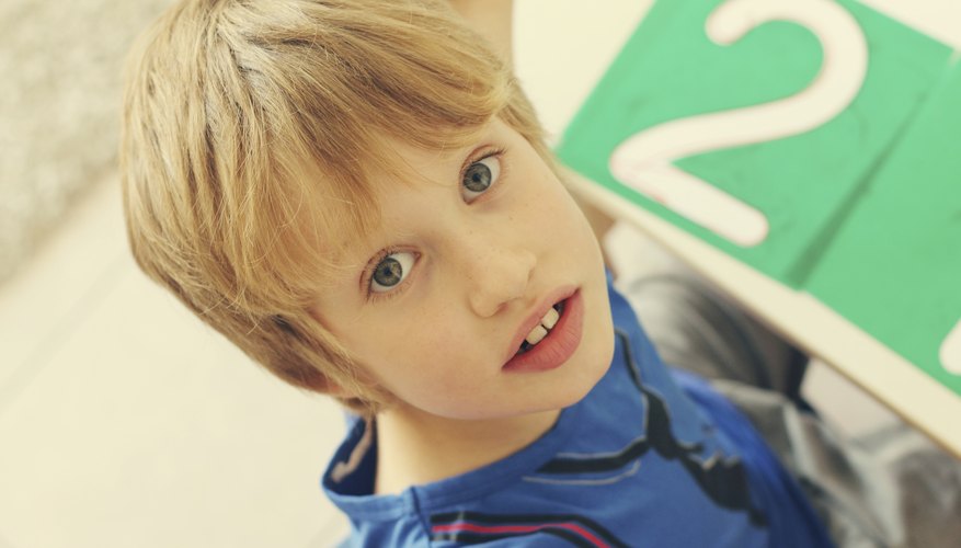 Child sitting at desk with giant