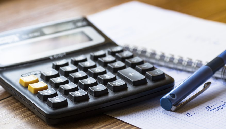 Calculator pen and notebook on table