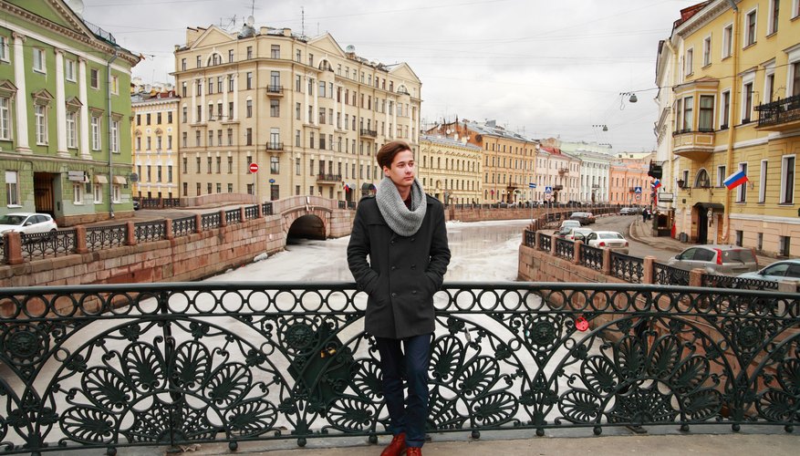 A young Russian man standing on a bridge.