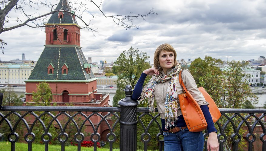 A stylish modern Russian woman standing in front of a building.