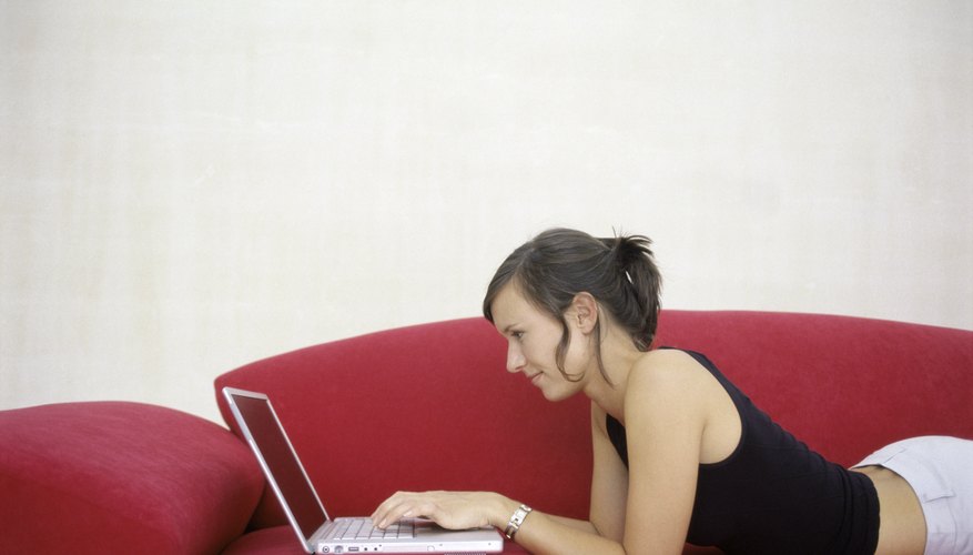 Woman using laptop on couch.