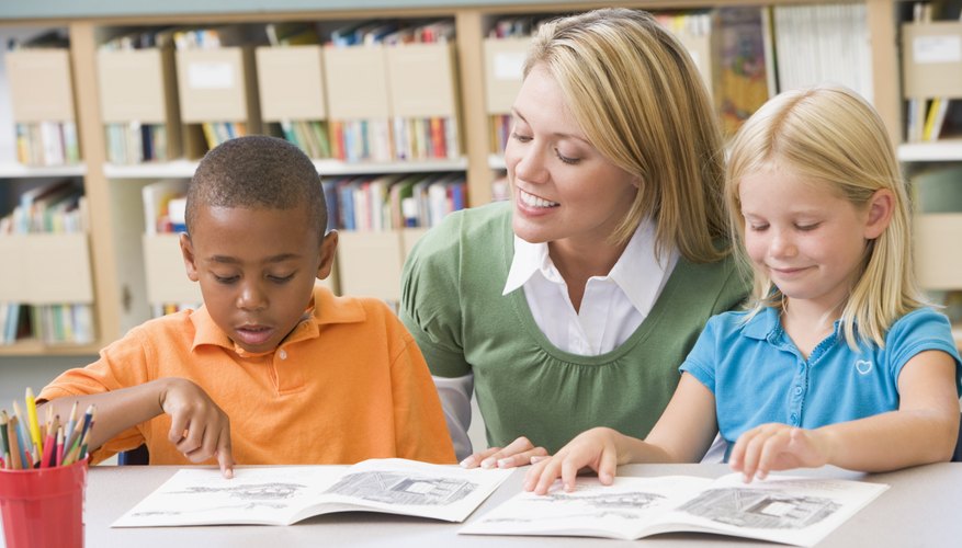 Teacher reading with young students in the library.
