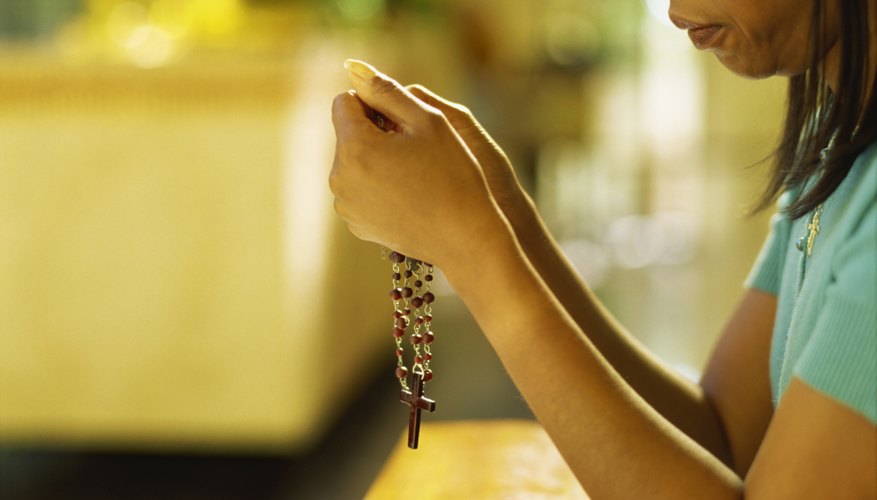 Praying the rosary, done here with a set of beads, is not mandatory at funerals.