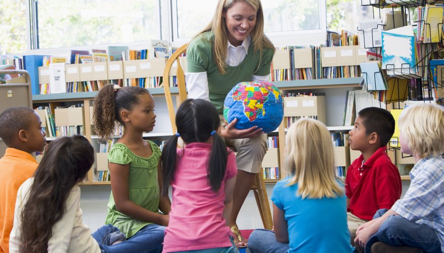 Kindergarten teacher showing globe to class.