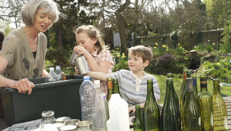 Children helping their grandmother recycle old bottles.