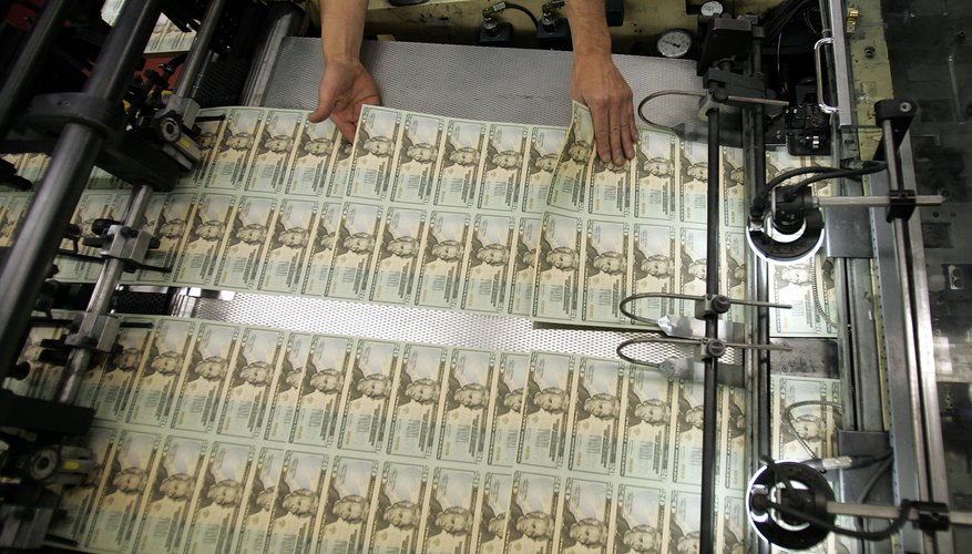 Worker looks for defective bills in newly printed U.S. twenty dollar bill sheets