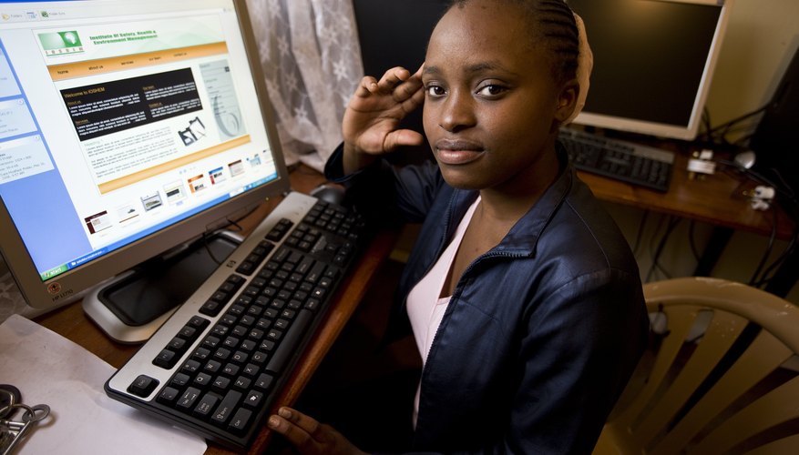 An adolescent girl opens a web page at a desk.