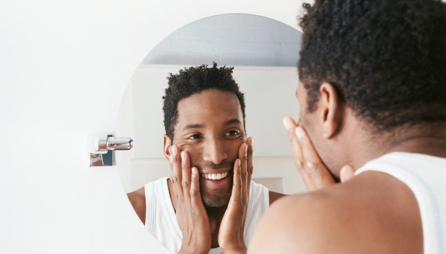 Man looking in wall mirror