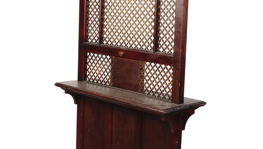 Catholic confession to a priest takes place through a wooden screen, as pictured, or face to face.