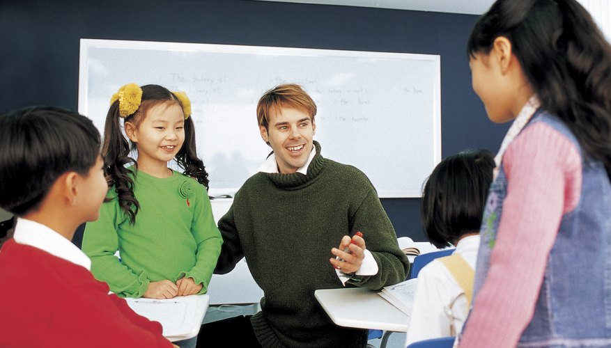 Teacher talking with young students in classroom