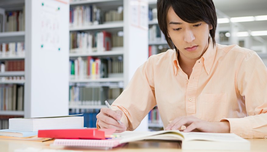 College student taking notes in library