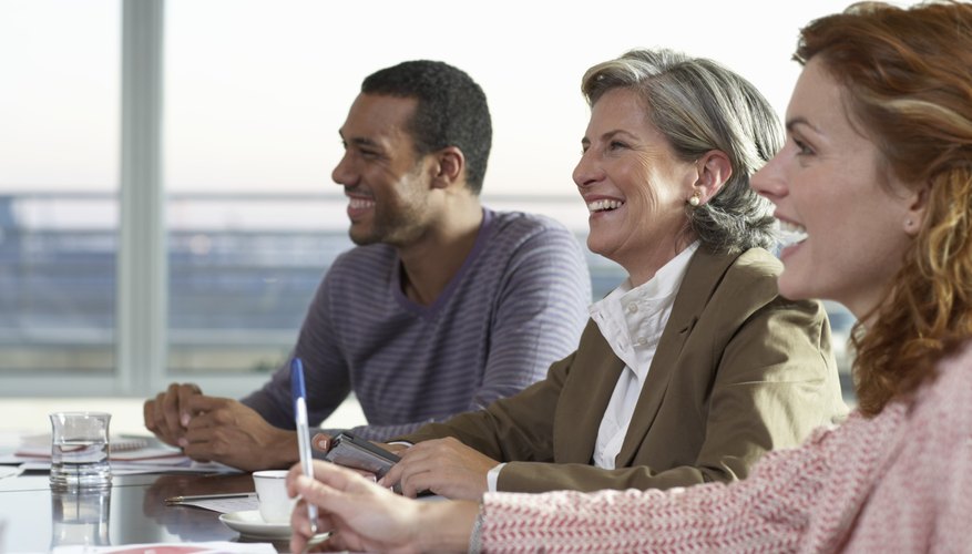Smiling employees at group meeting.