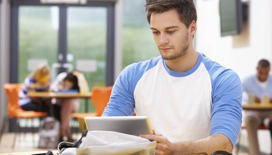 A male student is studying using his tablet.