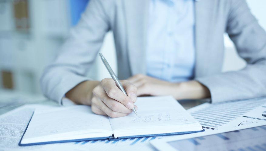 Woman writing in notebook on work desk