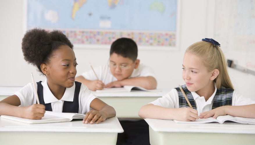 Smiling young students looking at each other in classroom