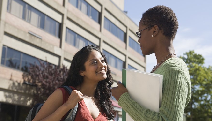 Teacher speaking with student on campus.