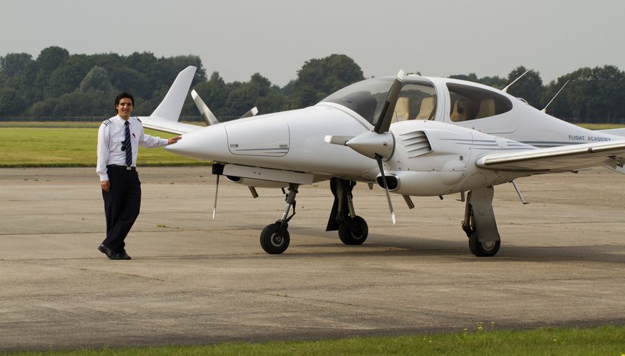 Young student pilot standing beside small plane