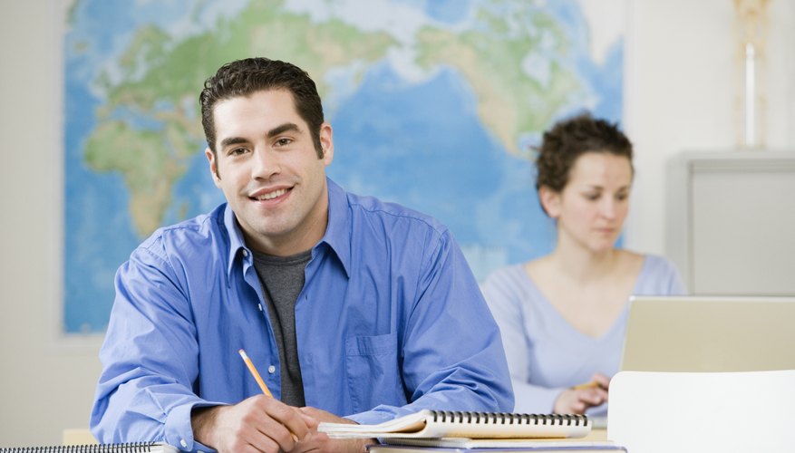Student writing in notebook while in classroom.